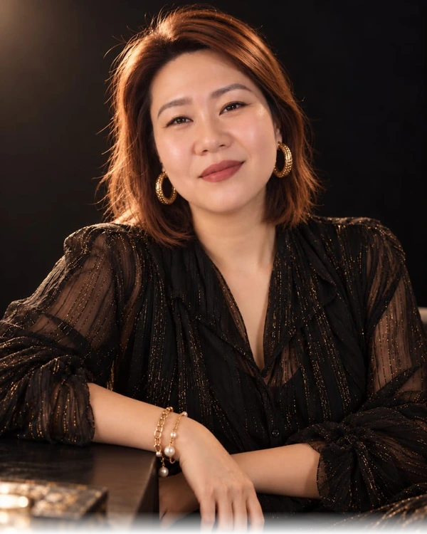 Winnie 的真實人物照片，黑金服裝坐姿肖像